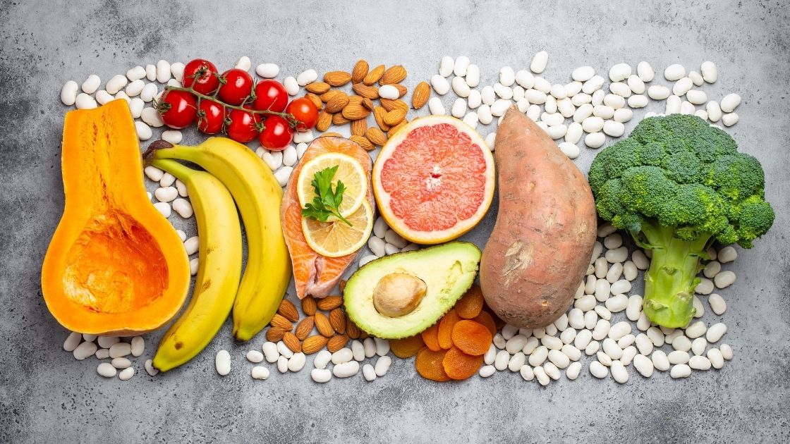 Healthy foods and white beans on gray table.