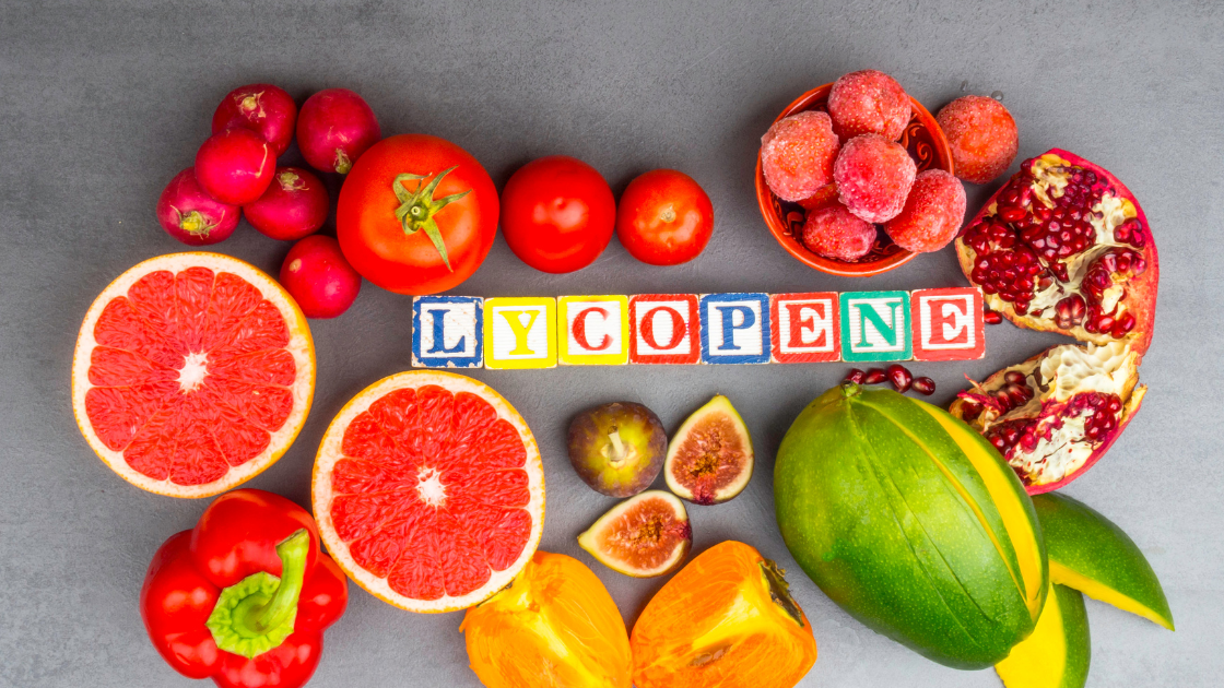 Lycopene text with colorful fruits on the gray table.